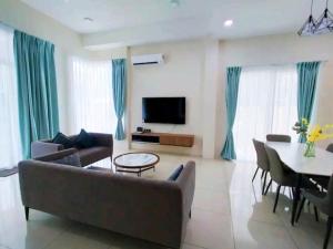 uma sala de estar com um sofá e uma mesa em GUESTHOUSE #2 Semi Bungalow House em Kuah