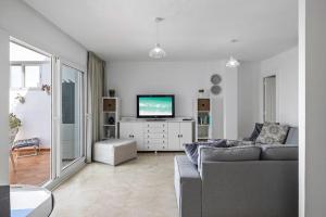een woonkamer met een bank en een tv bij Sea View Apartment at Wyndhams Complex in Málaga