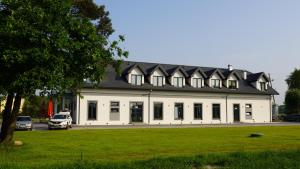 切霍齐内克Pensjonat Dębowy Dworek的黑色屋顶的白色大建筑