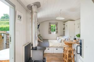 Habitación con cama y cocina con fogones. en Apple Blossom, Devon Hideaways, en Kenton