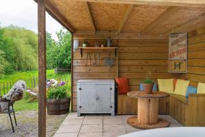 a wooden pergola with a table and a stove at Apple Blossom, Devon Hideaways in Kenton