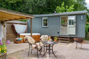 a tiny house with two dogs sitting on a patio at Apple Blossom, Devon Hideaways in Kenton