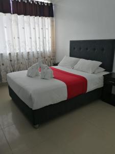 a bedroom with a bed with two stuffed animals on it at HOTEL LUCERO PARACAS in Paracas