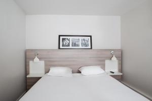 فندق كيرياد باريس ايست - بوا دي فينسين في سا موريس: غرفة نوم بسرير ابيض كبير ومصباحين