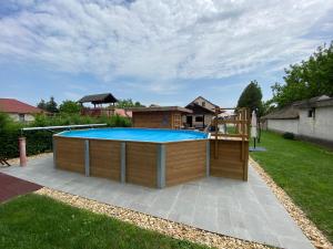 a large pool with a hot tub in a yard at Riviéra Apartmanok in Abádszalók