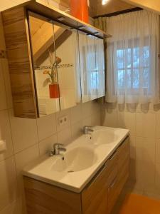 a bathroom with two sinks and a mirror and a window at CHALET GAMSBOCK Koralpe in Elsenbrunn +26 photos