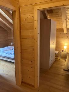 Pokój z łóżkiem i drewnianą ścianą w obiekcie CHALET GAMSBOCK Koralpe w mieście Elsenbrunn