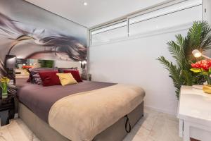 - une chambre avec un grand lit et une grande fenêtre dans l'établissement Village Naturiste - Xcape Sea View Luxe, au Cap d'Agde