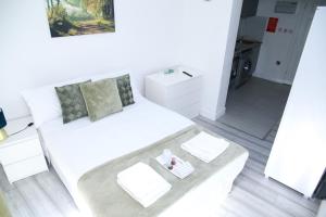 een woonkamer met een witte bank en een tafel bij Central Harrow Cozy Apartment with free parking in Harrow on the Hill