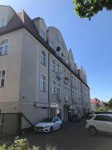 喬左維爾考普爾斯基的住宿－Apartament Rezydencja Przy Młynie，两辆车停在大楼前的建筑物