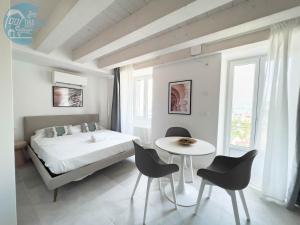 a bedroom with a bed and a table and chairs at San Rocco Sweet Apartments in Muggia