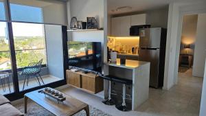 a kitchen with a stainless steel refrigerator and a table at Departamento Lujoso 1 Dormitorio cerca del Shoping del Sol in Asunción