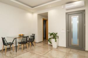 a dining room with a table and chairs and a door at Jarko Luxury Houses in Argoulidhés