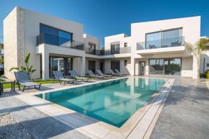 a house with a swimming pool in front of it at Jarko Luxury Houses in Argoulidhés