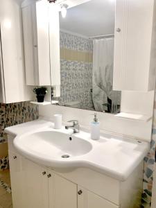 a bathroom with a white sink and a mirror at George Airport Apartments in Heraklio Town