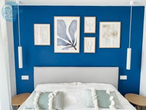een slaapkamer met een blauwe muur en een bed met kussens bij San Rocco Sweet Apartments in Muggia