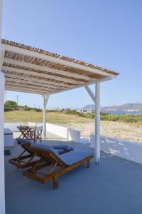 un patio con 2 sedie a sdraio e un pergolato in legno di Orion Milos a Pollonia