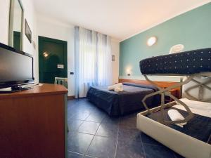 a room with a bedroom with a bed and a flat screen tv at Hotel Villa Grazia in Cesenatico