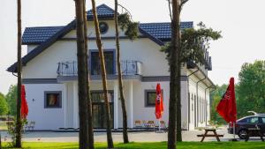 切霍齐内克Pensjonat Dębowy Dworek的一栋白色建筑，前面有树