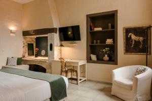 a bedroom with a bed and a desk and a chair at Alcanea Boutique Hotel in Chania Town