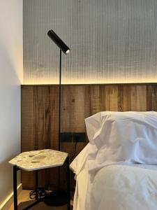 a bed with a lamp and a table next to it at Casa Papagayo in Córdoba