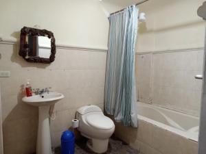 y baño con aseo, lavabo y bañera. en Huellas Hostal Antigua, en Antigua Guatemala
