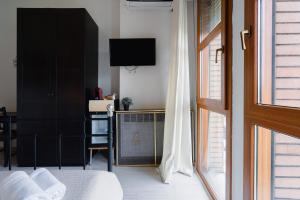 a bedroom with a bed and a tv and a window at B&B Elegance in Bologna