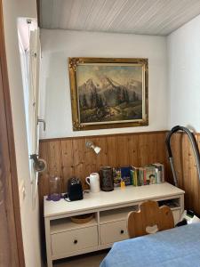 a bedroom with a painting on the wall and a table at Ferienwohnung Watzmannblick & Hallenbad in Berchtesgaden