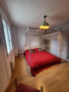 - une chambre avec un lit rouge à baldaquin dans l'établissement Maison les Asphodèles, à LʼIsle-sur-la-Sorgue