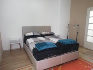 a large bed with blue pillows in a bedroom at Apartman Radanović in Foča