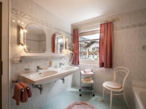 a bathroom with a sink and a tub and a mirror at Haus Eberharter in Mayrhofen