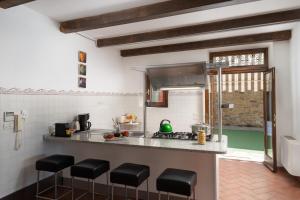 cocina con encimera y taburetes en una habitación en Villa Olivi, en Subbiano