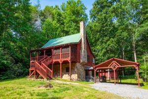 una baita in legno con un portico avvolgente e un tetto verde di Laurelwood Cabin Fireflies Paradise a Cosby