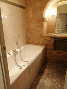 ein Badezimmer mit einer Badewanne und einem Waschbecken in der Unterkunft Maison Lambert in Domme