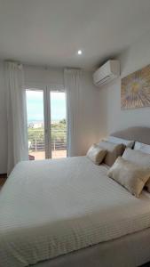 een groot wit bed in een slaapkamer met een raam bij A.Mare in Stintino