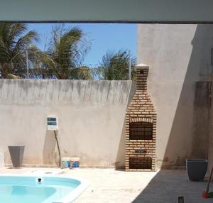 una chimenea de ladrillo junto a una pared con piscina en Casa em tibau RN, en Tibau do Sul