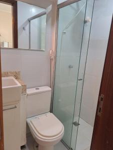 a bathroom with a toilet and a glass shower at Grand Ville Asa sul in Brasilia