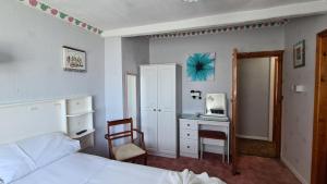 a bedroom with a bed and a desk with a microwave at The Kimberley B&B in Blackpool