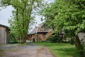 ein Haus mit einem Balkon und einem Garten mit Bäumen in der Unterkunft Tomatlyckan 1 in Vallåkra