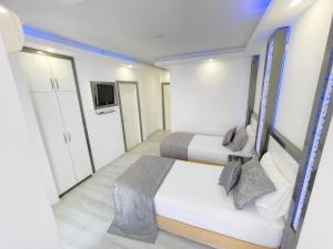 een kleine kamer met 2 bedden en een televisie bij Livane Sun Otel in Alanya