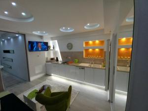 a large white kitchen with a tv on the wall at Apartman 101 in Sarajevo