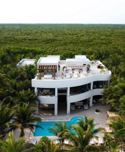 an aerial view of a building with a pool and palm trees at 8 Bedroom Luxury Villa with Private Chef Included in Tulum