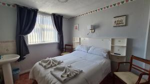 a bedroom with a bed and a sink and a window at The Kimberley B&B in Blackpool