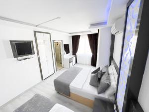 ein Hotelzimmer mit einem Bett und einem TV in der Unterkunft Livane Sun Otel in Alanya