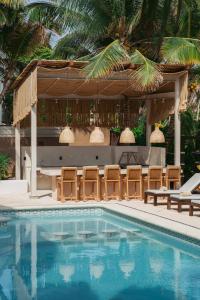 a swimming pool with chairs and a gazebo at 8 Bedroom Luxury Villa with Private Chef Included in Tulum
