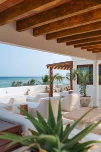 an outdoor patio with white furniture and the ocean at 8 Bedroom Luxury Villa with Private Chef Included in Tulum