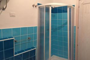 bagno con doccia e piastrelle blu di Residence Lentischi a Castelsardo