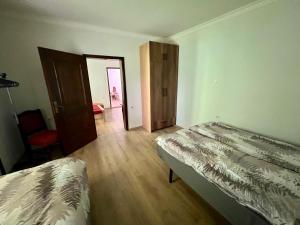 sypialnia z 2 łóżkami i drzwiami do pokoju w obiekcie Home Base Apartments w mieście Skopje