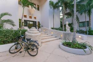 a bike parked in front of a building with palm trees at 8 Bedroom Luxury Villa with Private Chef Included in Tulum