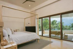 a bedroom with a bed and a view of the ocean at 8 Bedroom Luxury Villa with Private Chef Included in Tulum